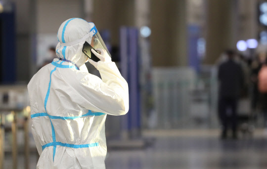 1일 인천공항에서 방역복을 입은 관계자가 통화하고 있다. 연합뉴스